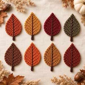 May include: Eight crocheted leaf appliques arranged in two rows. The leaves feature textured yarn stitches in autumn colors including orange, yellow, deep red, dark green, and brown. Each leaf has a central stem and a pointed tip design.
