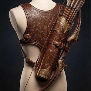 Puede incluir: Un arnés de pecho de cuero marrón con un intrincado relieve floral, junto con un carcaj a juego que contiene varias flechas de madera con plumas. Un arco recurvo con detalles en metal dorado está sujeto al lateral del carcaj.