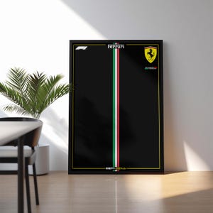 May include: A rectangular black poster in a thin black frame featuring a vertical tricolor stripe of green, white, and red down the center. The top includes the Ferrari logo, the F1 logo, and the text Ferrari. The bottom displays the text SF.