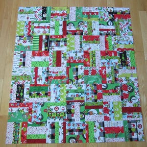 May include: A colourful patchwork quilt with a Christmas theme. The quilt is made up of various squares of fabric with different patterns, including Grinch characters, Christmas trees, and baubles. The quilt is a bright and festive addition to any home.