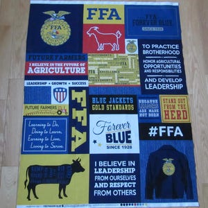 May include: A navy blue and yellow FFA (Future Farmers of America) fabric panel. The panel features various text blocks with phrases like "Forever Blue" and "Blue Jackets Gold Standards", along with illustrations of a goat, cow, and FFA emblem.