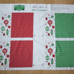 May include: A white fabric panel with four 14 x 18 inch placemats. Two placemats feature a red background with white polka dots and a green and red ornament design. The other two placemats feature a green background with white polka dots and a green and red ornament design. The fabric panel has the text "Merry Memories" and "Santas Stash" printed on it.