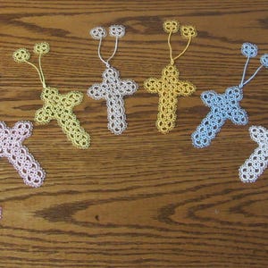 May include: A collection of ten handmade crocheted cross bookmarks in various pastel colors, including lavender, light blue, yellow, and purple.