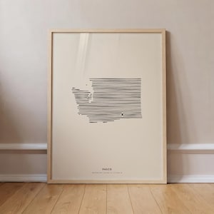 May include: A framed wall art print featuring a black line-art map of Washington state on a cream background. The map is composed of horizontal lines with a small star marking the location of Pasco. Text below reads PASCO WASHINGTON.