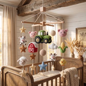 Op de afbeelding: Een hangende babymobiel met gehaakte boerderijfiguren, waaronder een groene tractor, een rode schuur, een roze varken, een wit schaap, een koe, een geel kuikentje en een maïskolf, afgewisseld met diverse sterren, wolken en bollen.