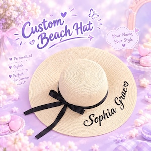 Op de afbeelding: Een beige strooien strandhoed met een zwart lint dat in een strik om de kroon is gebonden. De rand is geborduurd met de naam Sophia Grae in zwarte schrijfletters. De hoed wordt getoond tegen een paarse achtergrond met tekst.