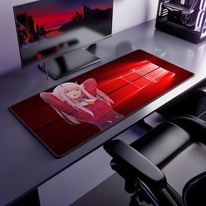 May include: A rectangular desk mat featuring a red background with a white Windows logo and an anime character with long pink hair, wearing a red outfit, positioned on the left side of the mat. The mat has a black border and a smooth surface.