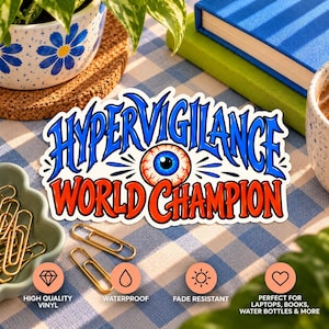 May include: A die-cut sticker featuring the text HYPERVIGILANCE WORLD CHAMPION in bold blue and orange lettering. A realistic, detailed human eyeball with blue iris and red veins is centred between the words. The sticker has a white border.