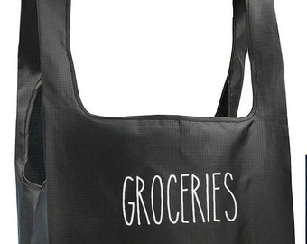 May include: A black reusable grocery bag with white text that says "GROCERIES".