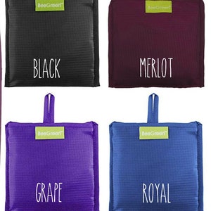 May include: Four reusable shopping bags in different colors: black, burgundy, purple, and blue. Each bag has a green label with the text "BeeGreen" and a white text label with the color name: "BLACK", "MERLOT", "GRAPE", and "ROYAL".