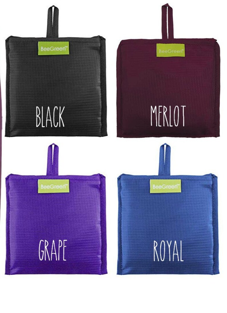 May include: Four reusable shopping bags in different colors: black, burgundy, purple, and blue. Each bag has a green label with the text "BeeGreen" and a white text label with the color name: "BLACK", "MERLOT", "GRAPE", and "ROYAL".