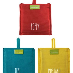 May include: Three reusable shopping bags in different colors: red, teal, and yellow. The bags are folded and have a handle. The bags have the words "BeeGreen" and "Poppy", "Teal", and "Mustard" printed on them.