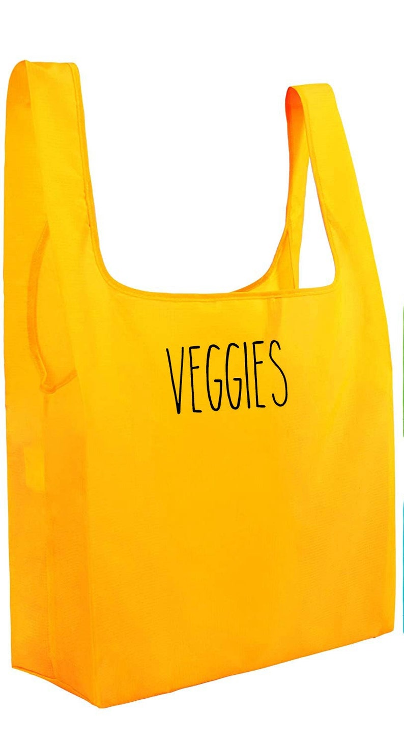 May include: A bright yellow reusable grocery bag with the word "VEGGIES" printed in black on the front.
