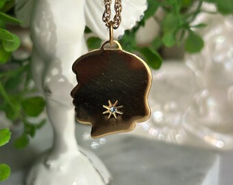 Vintage Avon girl silhouette with small sparkly blue stone pendent gold tone like new!