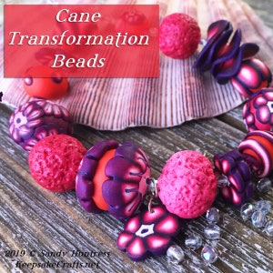 May include: A close-up of a colorful polymer clay bead bracelet featuring a variety of textures and patterns. The beads are in shades of pink, red, and purple. The bracelet is displayed on a wooden surface with a seashell.