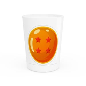 May include: A white shot glass featuring a graphic of a round, orange sphere with four red stars arranged in a square pattern. The sphere has light yellow highlights on the left side, giving it a glossy, spherical appearance against the white surface.