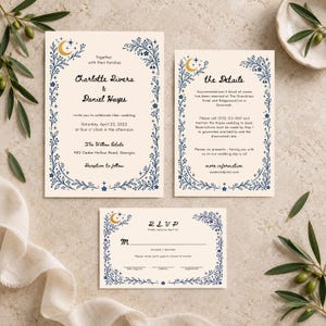 May include: A wedding invitation suite on cream paper featuring a blue floral border with gold crescent moons and stars. The text includes names Charlotte Rivera and Daniel Hayes, The Willow Estate, and RSVP details with a request for entree choices.