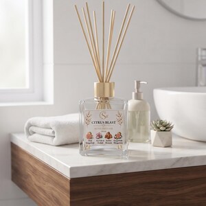 May include: A clear glass square home diffuser bottle with a gold cap and wooden reeds. The label reads CITRUS BLAST HOME DIFFUSER and lists scents including Pink Grapefruit, Sea Salt & Amber Orchid, Element, and Grapefruit Mangosteen.