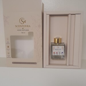 May include: A 100 ml Scentovra home diffuser in a beige box. The bottle has a gold cap and a label reading Fresh Clean with floral illustrations. The box features the Scentovra logo, text about long-lasting fragrance, and the phrase Scents That Elevate Every Space.