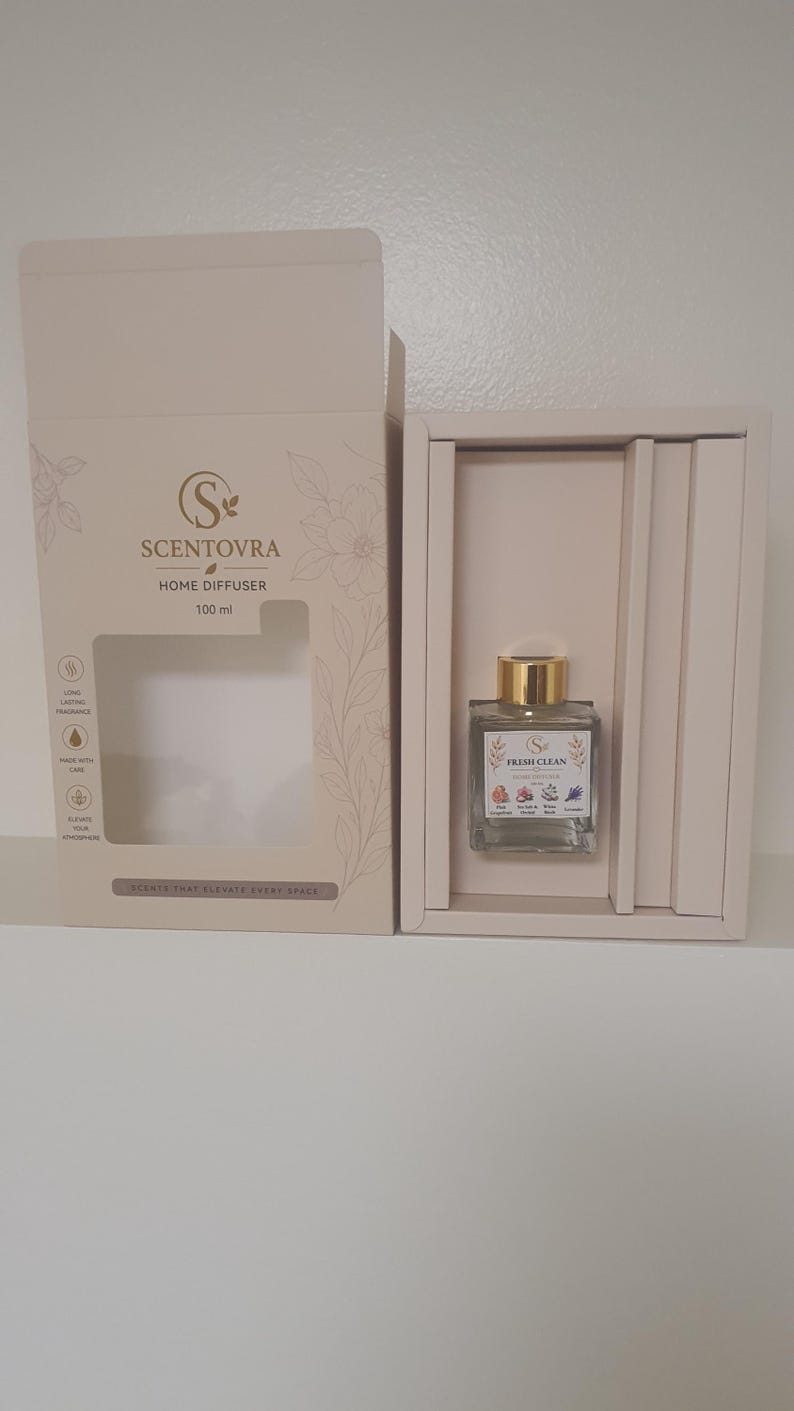 May include: A 100 ml Scentovra home diffuser in a beige box. The bottle has a gold cap and a label reading Fresh Clean with floral illustrations. The box features the Scentovra logo, text about long-lasting fragrance, and the phrase Scents That Elevate Every Space.