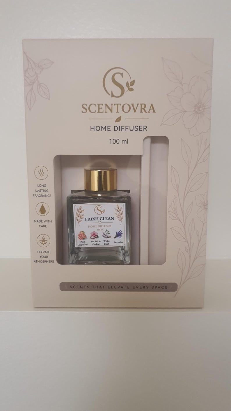 May include: A Scentovra home diffuser set in a beige box with floral line art. The 100 ml glass bottle has a gold cap and a label reading Fresh Clean Home Diffuser with icons of Pink Grapefruit, Sea Salt & Orchid, White Birch, and Lavender.