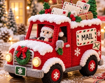 Puede incluir: Un camión de correo rojo tejido a ganchillo con detalles de nieve blanca, conducido por una figura de Santa Claus. El camión tiene una corona verde al frente, un letrero 'MAIL' en el lateral y una carga llena de regalos, sobres y un árbol.
