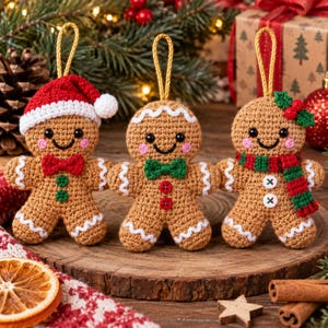May include: Three crocheted gingerbread ornaments with gold hanging loops. The left one wears a red Santa hat and bow tie. The center one has a green bow tie and red buttons. The right one features a red and green scarf and a holly sprig.