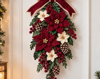 May include: A crochet Christmas wall hanging featuring a large dark red bow at the top, deep red and cream poinsettia flowers, green foliage, clusters of red berries, and brown pinecones arranged in a vertical teardrop-shaped swag.