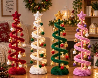 May include: Four spiral-shaped crochet Christmas trees in red, white, green, and pink. Each tree features a star topper, a central pole, a circular base, and is decorated with small hanging metallic ornaments and integrated string lights.