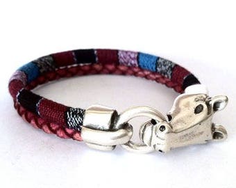 Op de afbeelding: Een multi-kleurig stoffen armband met een zilveren paardenkop sluiting.