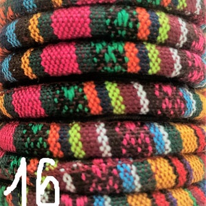 Puede incluir: Primer plano de una pila de cordones tejidos de colores. Los cordones est&aacute;n hechos de una variedad de colores, incluyendo rojo, verde, azul y amarillo. Los cordones est&aacute;n dispuestos en una pila de seis, con el n&uacute;mero "16" escrito en blanco en el cord&oacute;n inferior.