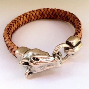 May include: A braided leather bracelet with a silver horse head clasp.