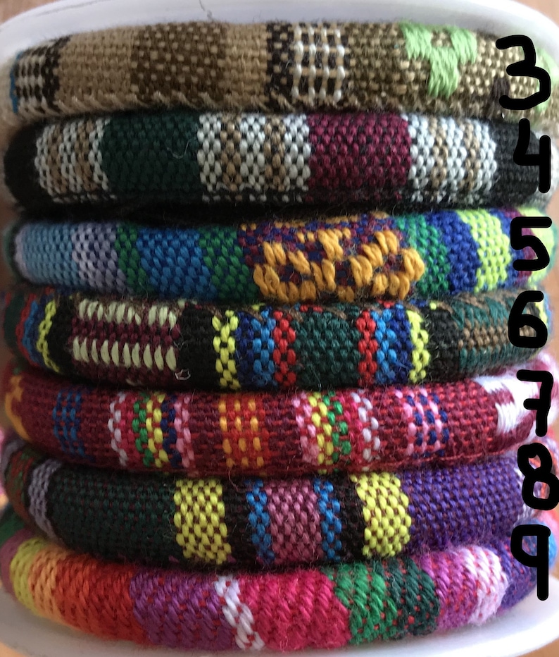 Puede incluir: Una pila de nueve bandas de tejido tejido de colores, cada una con un patr&oacute;n diferente. Las bandas est&aacute;n apiladas en orden de mayor a menor, con la banda m&aacute;s grande en la parte inferior y la banda m&aacute;s peque&ntilde;a en la parte superior. Las bandas est&aacute;n todas hechas de un tejido suave y tejido y tienen una variedad de colores, incluidos rojo, azul, verde, amarillo y marr&oacute;n.