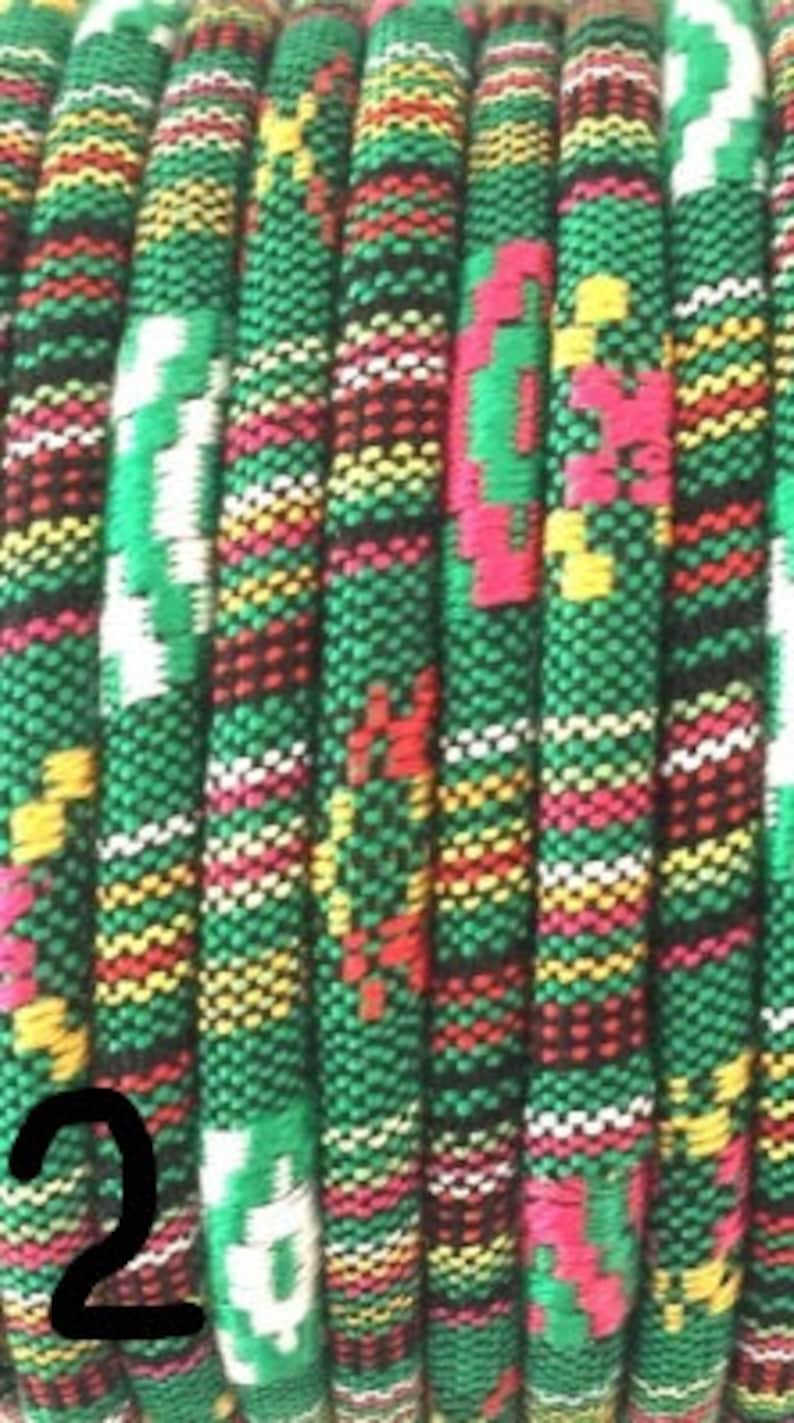 Puede incluir: Borde tejido multicolor con un patr&oacute;n verde, negro, blanco, amarillo y rosa. El borde est&aacute; hecho de una tela suave y texturizada.