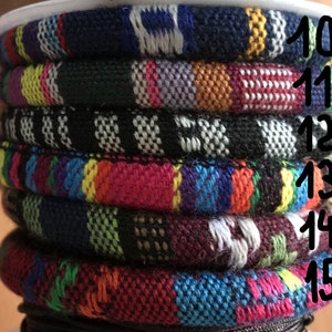 Puede incluir: Una pila de pulseras tejidas de colores con los n&uacute;meros del 10 al 15 impresos en el lado derecho de la imagen.