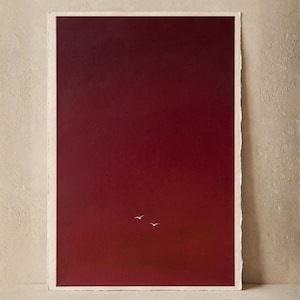 Peut inclure: Une impression d'art rectangulaire présentant un fond en dégradé allant du bordeaux profond au rouge foncé. Deux petites silhouettes d'oiseaux blanches et minimalistes sont placées au centre inférieur. Le bord est effiloché.
