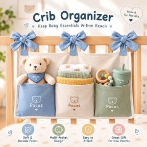 May include: A beige fabric crib organizer with three pockets, featuring blue, beige, and green sections. Each pocket displays a bear icon and the text Pocas. The organizer is attached to a wooden crib with three blue fabric bows.