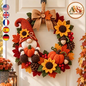 May include: A crochet autumn wreath featuring a gnome with a tall orange hat, a white beard, and a small pumpkin. The wreath is decorated with orange and yellow sunflowers, red berries, brown pinecones, acorns, and orange maple leaves.