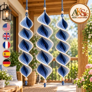 May include: Three hanging spiral ornaments crafted from blue and white yarn, featuring a twisted, ribbed texture. Each piece is suspended by a blue cord with a small wooden bead at the top and bottom, creating a vertical, decorative display.
