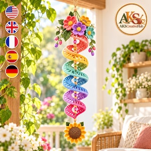 May include: A hanging crochet spiral decoration featuring a rainbow gradient of colors, topped with a cluster of colorful crocheted flowers and green leaves, and finished with a large yellow sunflower at the bottom, accented by beads.