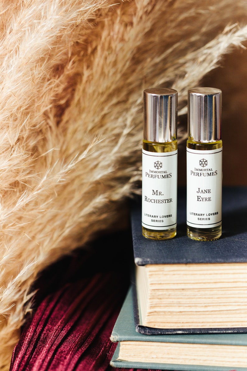 May include: Two small glass bottles of perfume with silver caps. The bottles are labelled "Immortal Perfumes" and feature the names "Mr. Rochester" and "Jane Eyre" from the Literary Lovers series.
