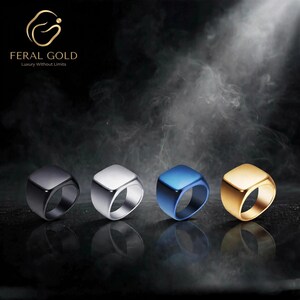 May include: Four square-shaped signet rings arranged in a row, featuring black, silver, blue, and gold metallic finishes. The top left corner displays the Feral Gold logo with the text Feral Gold Luxury Without Limits in a dark, smoky setting.