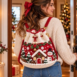 Könnte beinhalten: Ein gehäkelter Rucksack mit Kordelzug und weihnachtlichem Motiv, das ein Lebkuchenhaus, einen Schneemann und Tannenbäume auf rotem Grund zeigt. Die Tasche hat cremefarbene Ränder, rote Träger und eine kleine goldene Glocke als Verzierung.