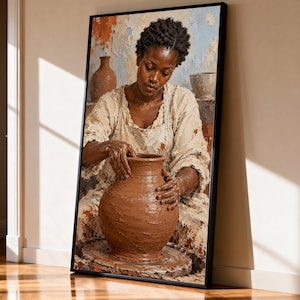 May include: A framed wall art print depicting a person with short dark hair wearing a textured cream-colored garment, actively shaping a large, wet brown clay vessel on a pottery wheel, with additional clay pots visible in the background.