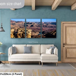 May include: A three-panel canvas wall art set depicting a Grand Canyon landscape with rocky cliffs and a blue sky. The artwork is displayed above a cream-colored sectional sofa. Text on the image includes Livingroom size chart and 40x90in.
