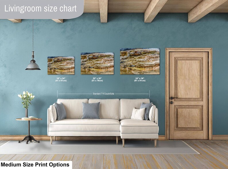 May include: A living room size chart displaying three rectangular landscape wall art prints above a cream-colored sectional sofa. The prints show a rocky, layered geological formation. Sizes listed are 16x24 inches, 20x30 inches, and 24x36 inches.