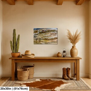 May include: A rectangular wall art print depicting a layered geothermal terrace with mineral deposits in shades of brown, tan, and white. The print measures 20 by 30 inches and is displayed on a beige wall above a wooden console table.