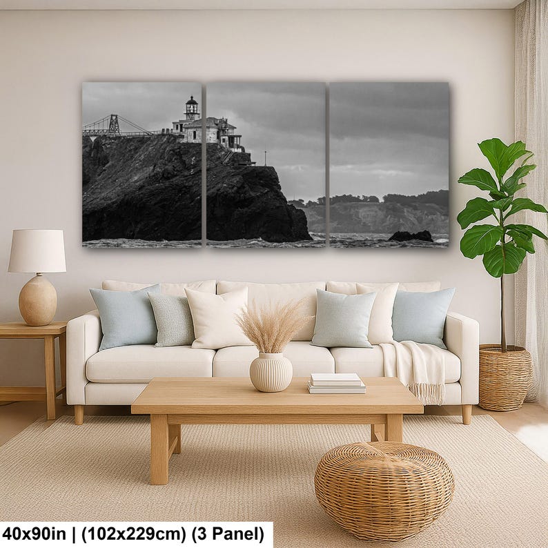 May include: A three-panel black and white wall art set depicting a lighthouse perched on a rocky cliffside with a bridge structure in the background. The total dimensions of the artwork are 40 inches by 90 inches, displayed as three panels.