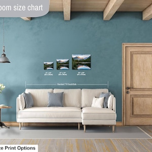May include: A living room size chart displaying three landscape prints of a mountain lake above a cream-colored sectional sofa. The prints are labeled with dimensions 8" x 10", 11" x 14", and 16" x 20". Text includes "Livingroom size chart" and "Standard 7 ft Couch/Sofa".