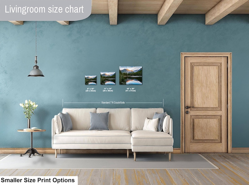 May include: A living room size chart displaying three landscape prints of a mountain lake above a cream-colored sectional sofa. The prints are labeled with dimensions 8" x 10", 11" x 14", and 16" x 20". Text includes "Livingroom size chart" and "Standard 7 ft Couch/Sofa".